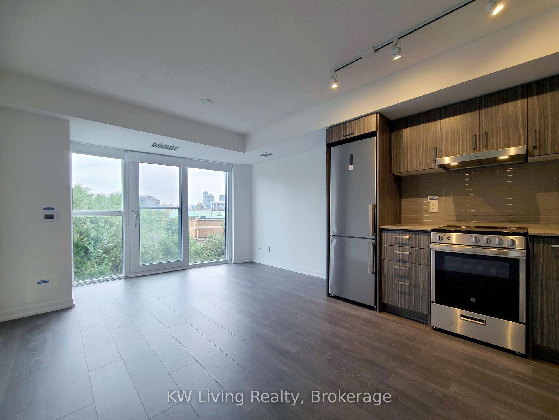 In. De Condo by Menkes Modern Studio at Dundas amp ; Jarvis, Spacious studio suite with a sleek, modern kitchen featuring built in appliances and stone countertops.