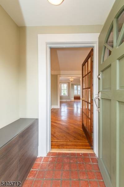 This Charming Dutch Colonial with Craftsman accents like chestnut trim, stunning crown moldings, leaded glass windows, oak floors w walnut ribbon trim, is light filled and inviting !