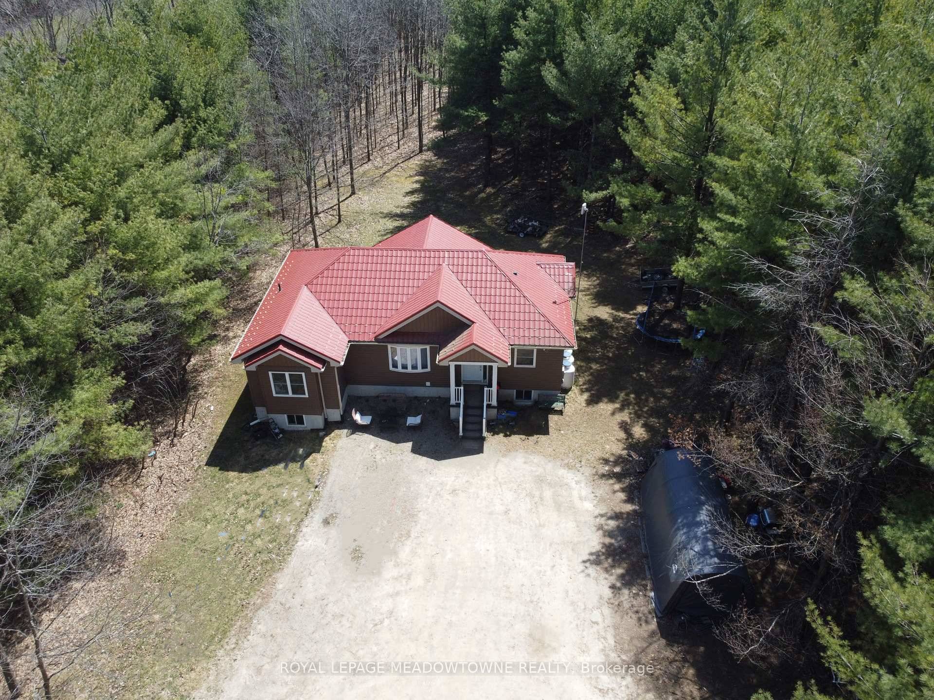 Raised bungalow with walk out basement sits on a peaceful 1 acre lot surrounded by mature trees, tucked away on a quiet country road.