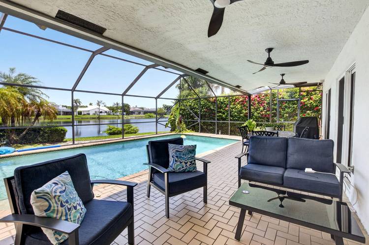 Experience the best of East Boca living in this beautifully reimagined four bedroom, two and a half bath residence, nestled within an exclusive private gated lakefront community.