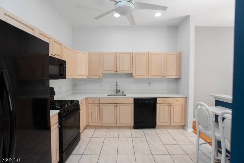 Step inside to a naturally lit living room featuring soaring ceilings, a spacious kitchen with breakfast bar, and an inviting dining area ideal for entertaining or relaxed everyday living.