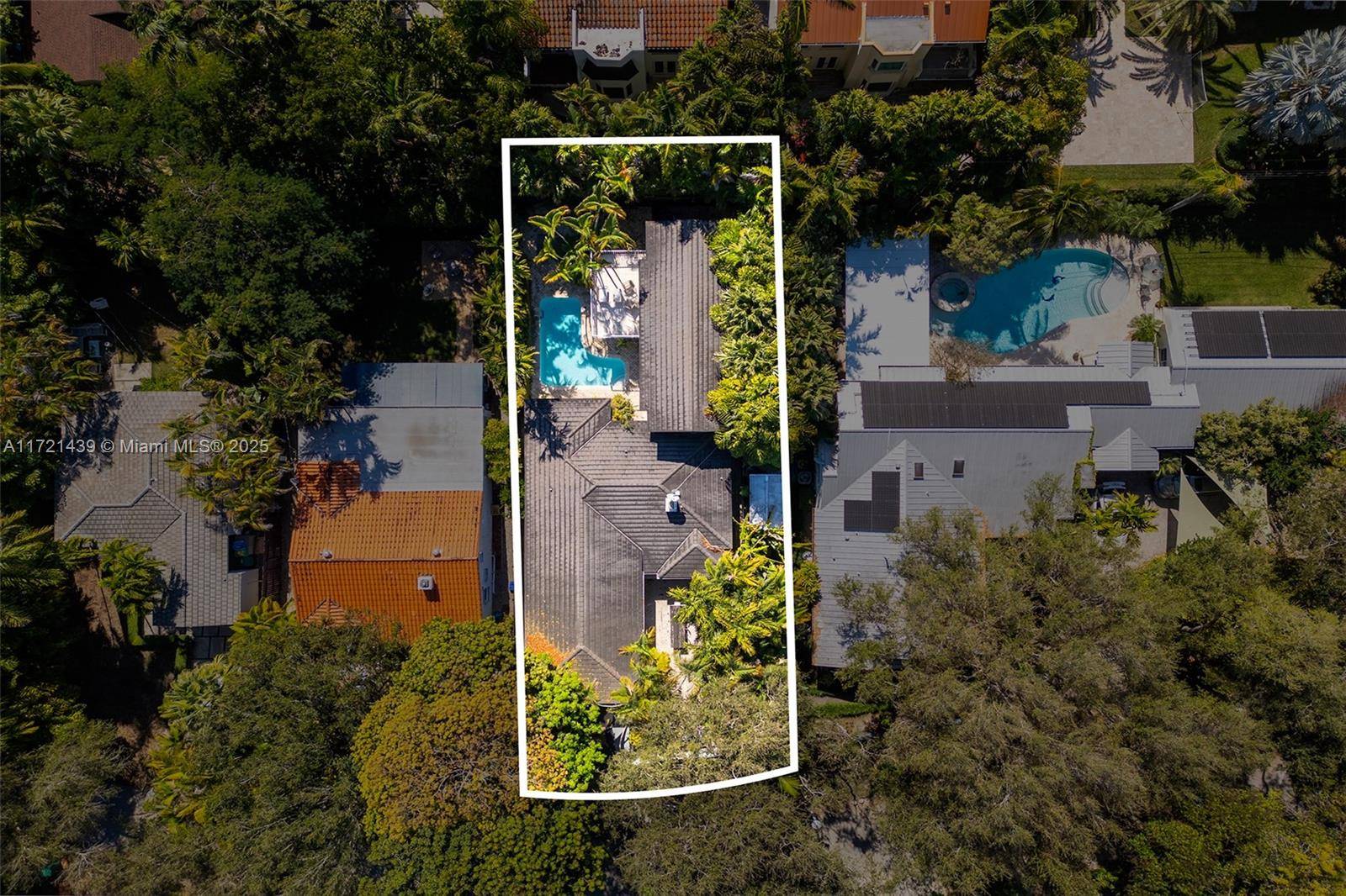 Captivating tropical retreat on a tree canopied street in lush South Coconut Grove.