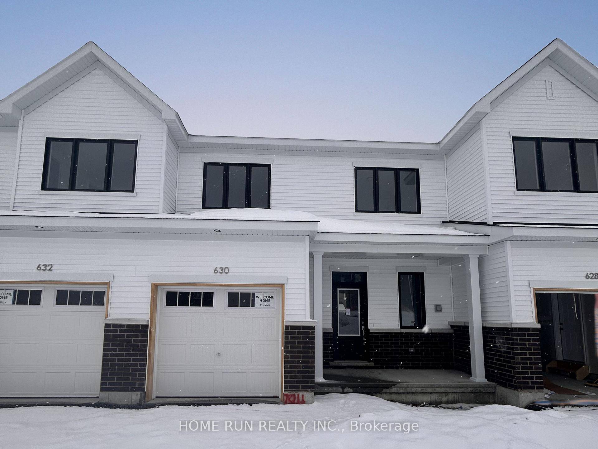 This modern 2025 townhouse features an upgraded kitchen with quartz countertops, an eat in breakfast counter, and sleek white cabinetry with brand new stainless steel appliances.