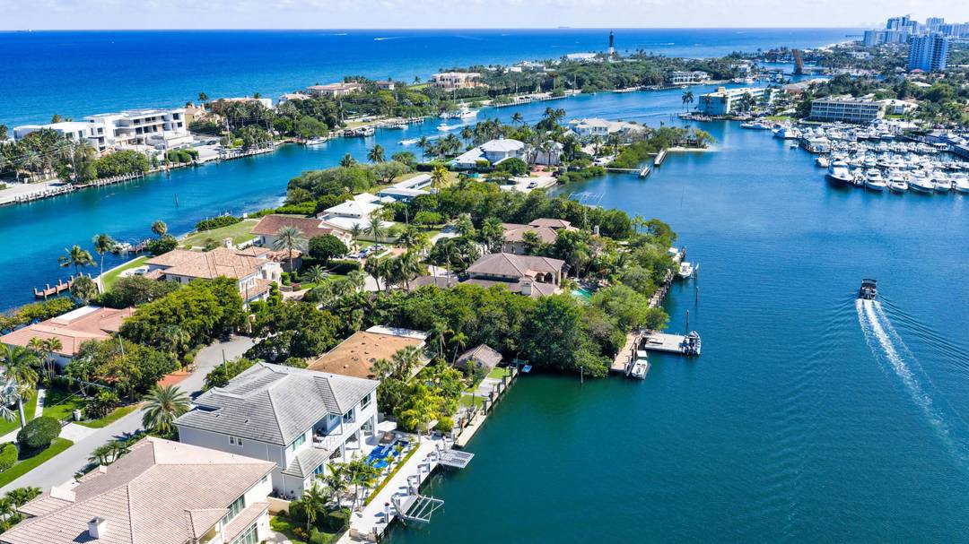 Gated, Coastal Contemporary Deepwater Estate sited on 75' of waterfrontage with wide, spell binding views of Lake Placid on Lighthouse Point s prestigious Intracoastal Drive.