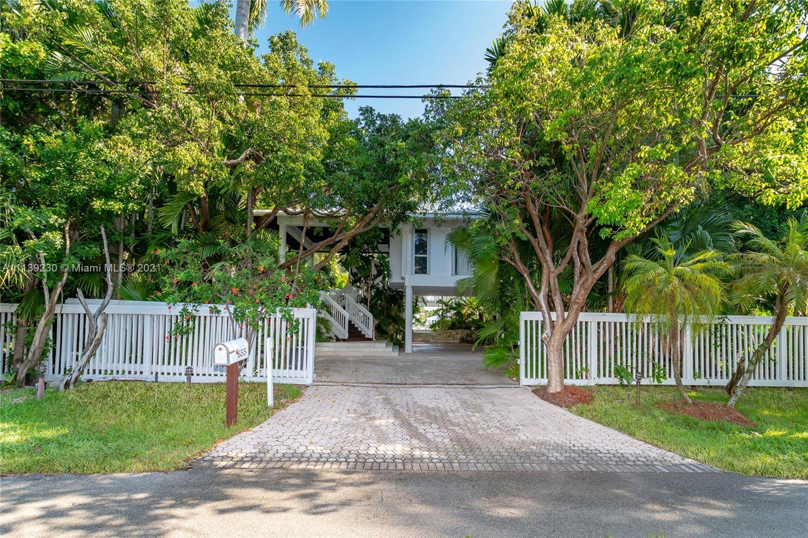 This tropical pod house with heated pool and summer kitchen over look a protected harbor with calm water sunset views.
