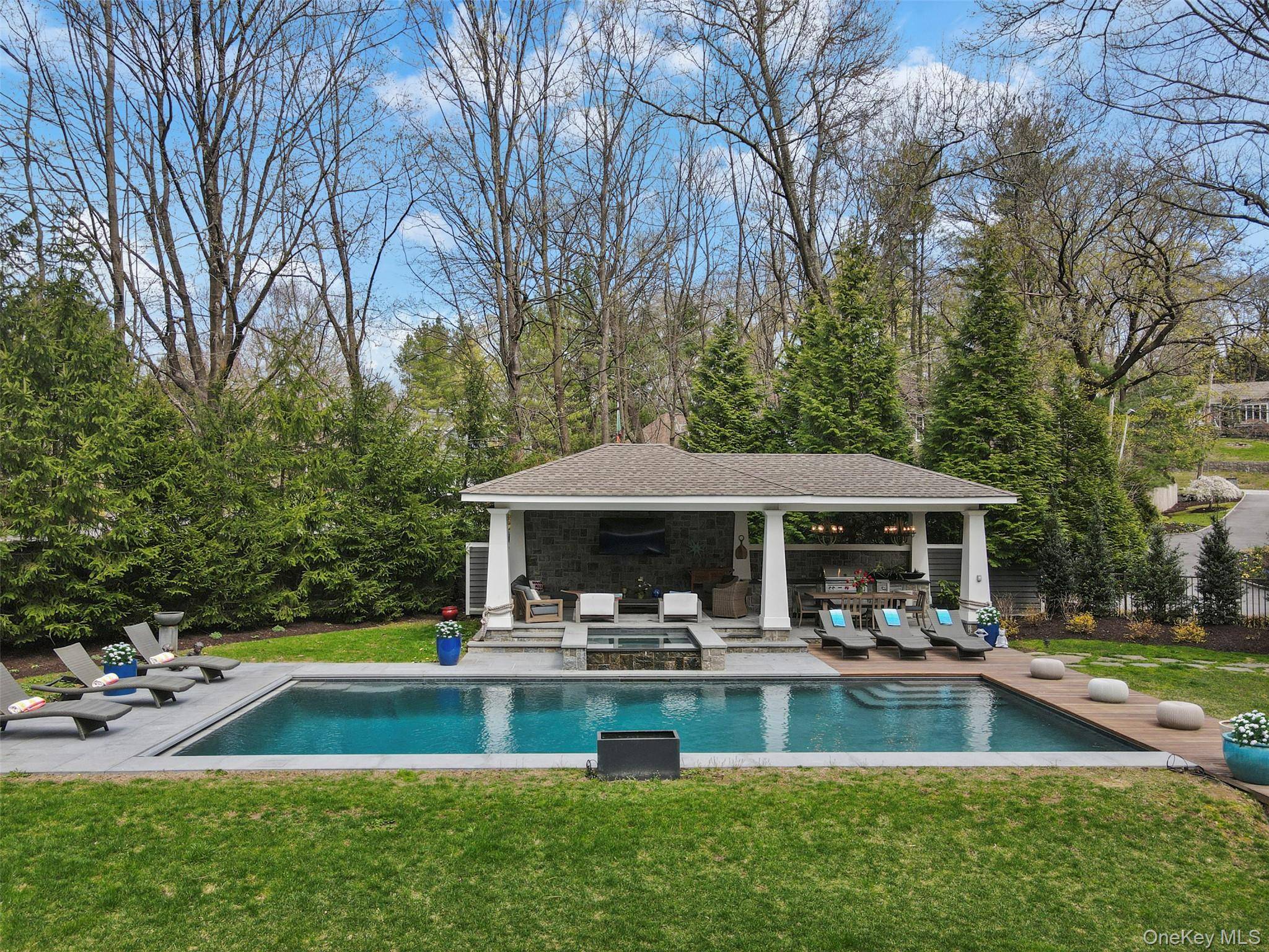 Set on 3. 19 acres of tranquil woodland in a coveted Rye Brook enclave, this exceptional contemporary residence offers privacy and seamless indoor outdoor living.