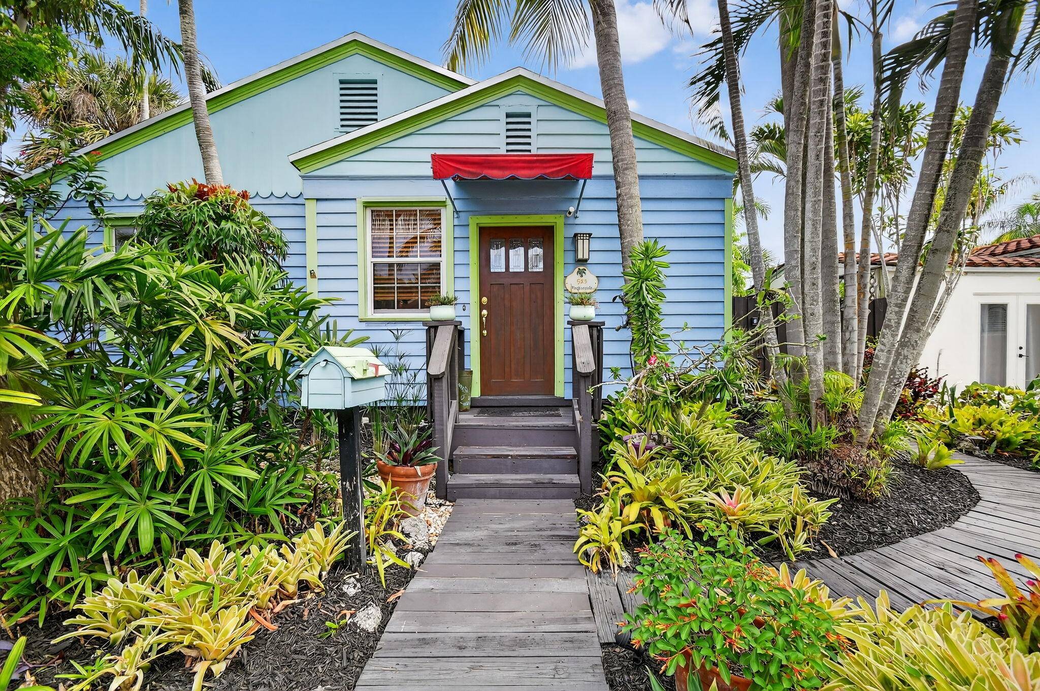 Charming Key West Style Home, surrounded by lush, tropical landscaping.