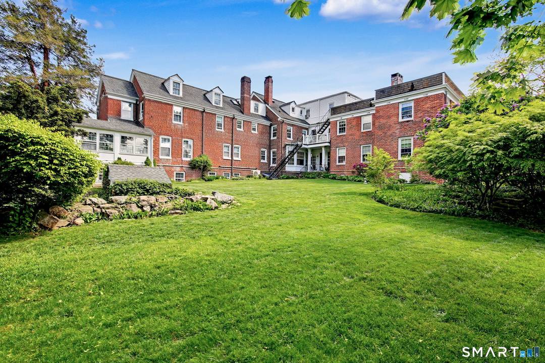 A circular drive and lush front lawn greet you at this brick 1910 mansion, which has been thoughtfully converted into nine charming residences.
