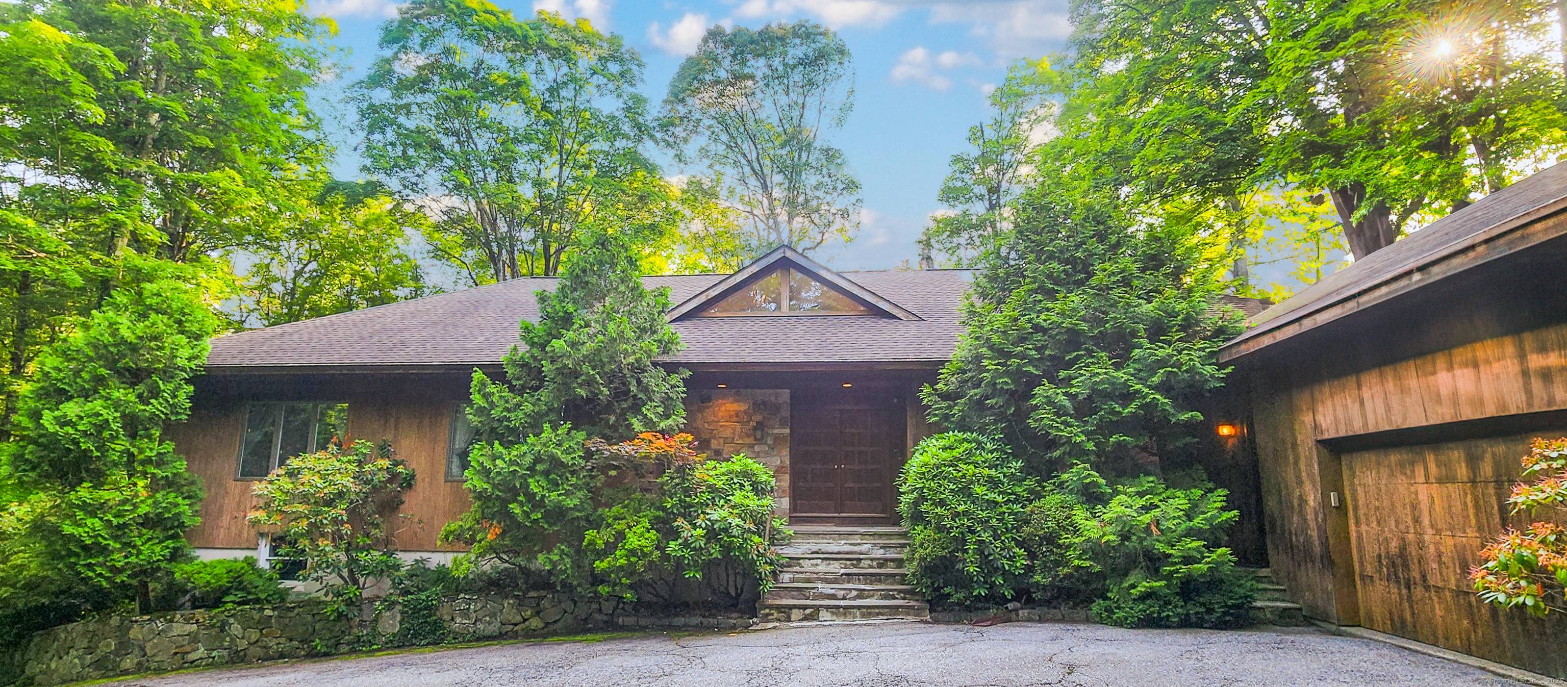 Set atop a long, private drive, this stunning contemporary home offers tranquility in bucolic North Stamford.