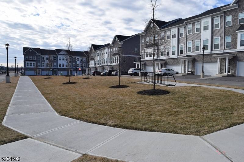 Tri level Townhome in a young complex Open concept living area with high ceilings Kitchen with white shaker cabinets quartz counters, island stainless steel appliances Wide plank wood floors recessed ...