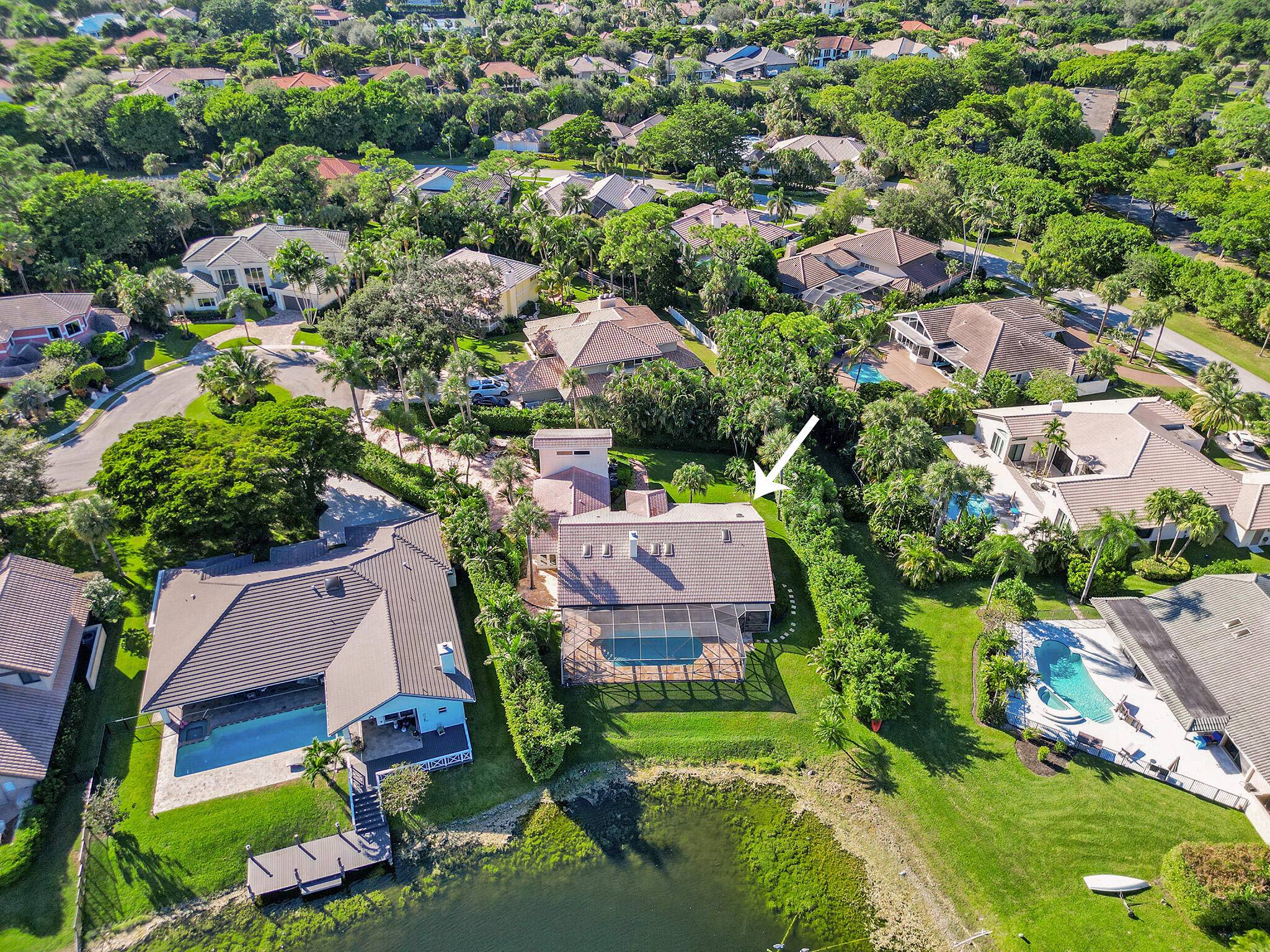 A unique opportunity to own this gorgeous private estate located on a waterfront lot in the charming gated community of Boca Raton Sailing Racquet Club.