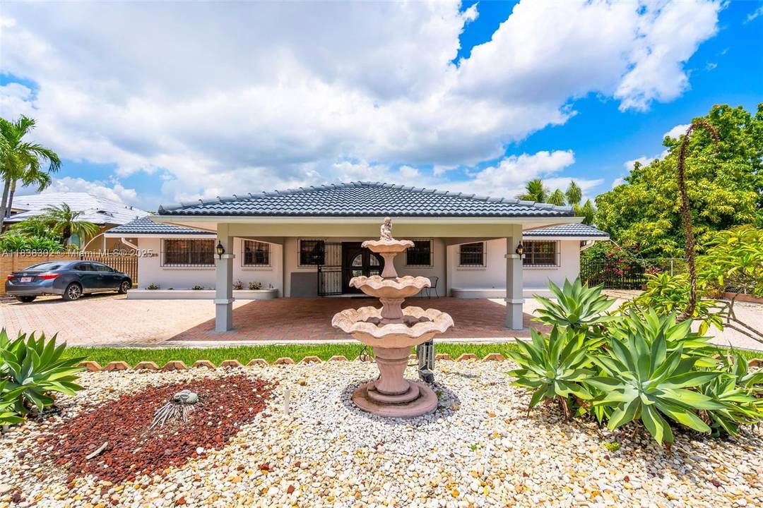 This 4 bedroom, 2 bathroom property features a circular driveway and a large carport space.