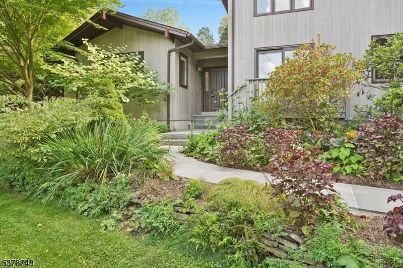 Welcome to this custom mid century modern home located on one acre with a stunning English style garden and inground heated pool, your private outdoor oasis !