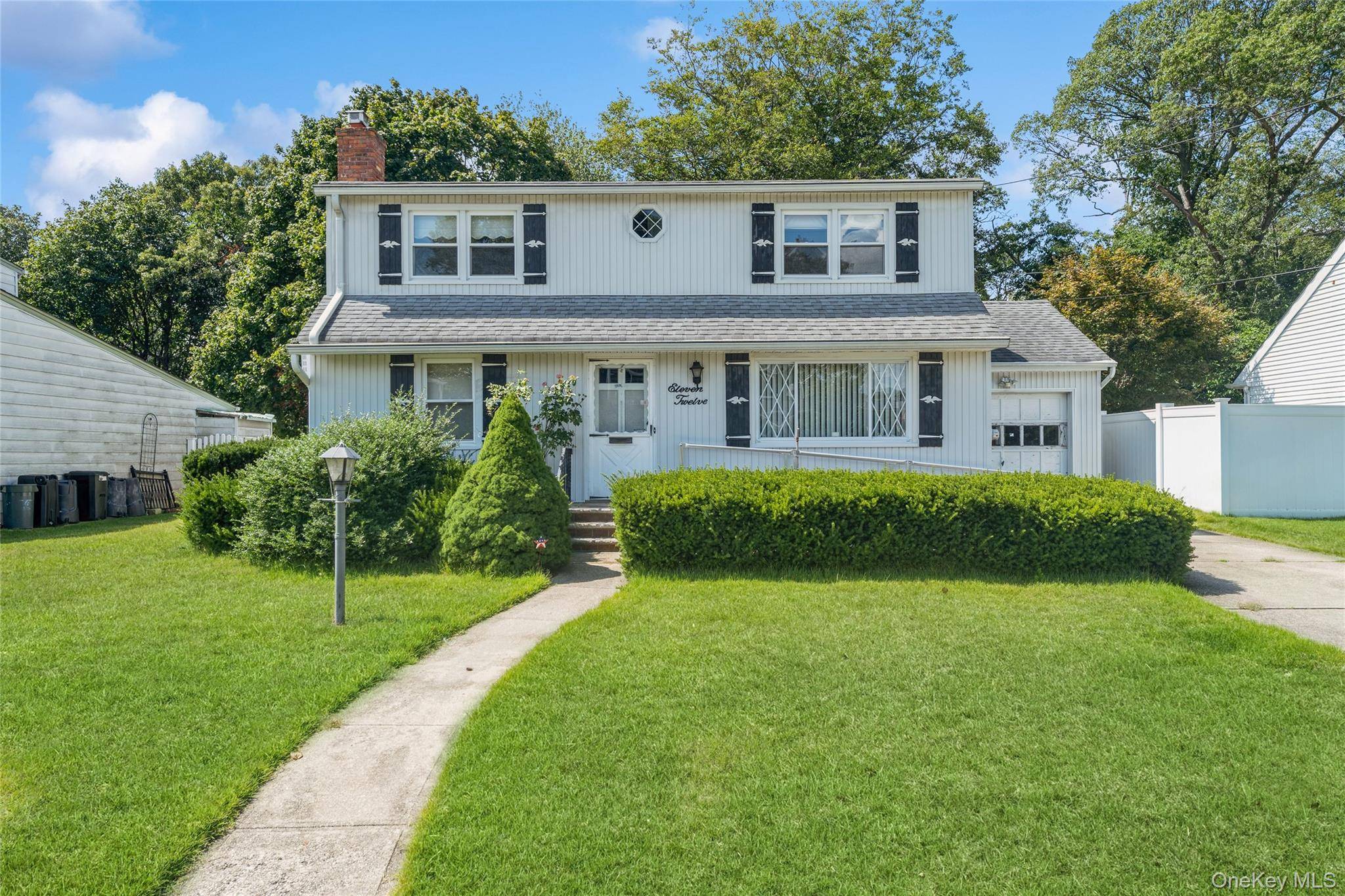 Charming Colonial in N. Merrick backing up to a lush wooded area for the ultimate privacy !