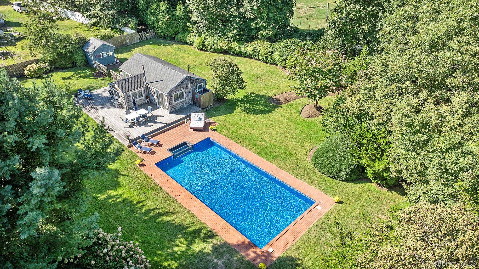 Privately situated amp ; set back from the road, this charming East Hampton cottage features over 1 2 an acre of cleared, luscious property.