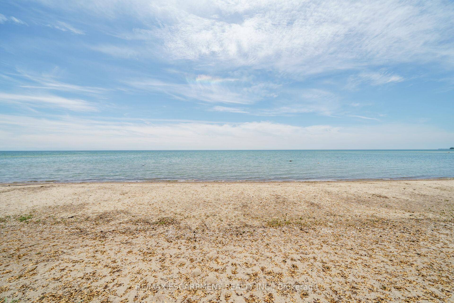Spectacular lakefront escape, right on the water, enjoy private sandy beach, crystal blue lake, lush foliage with mature trees.