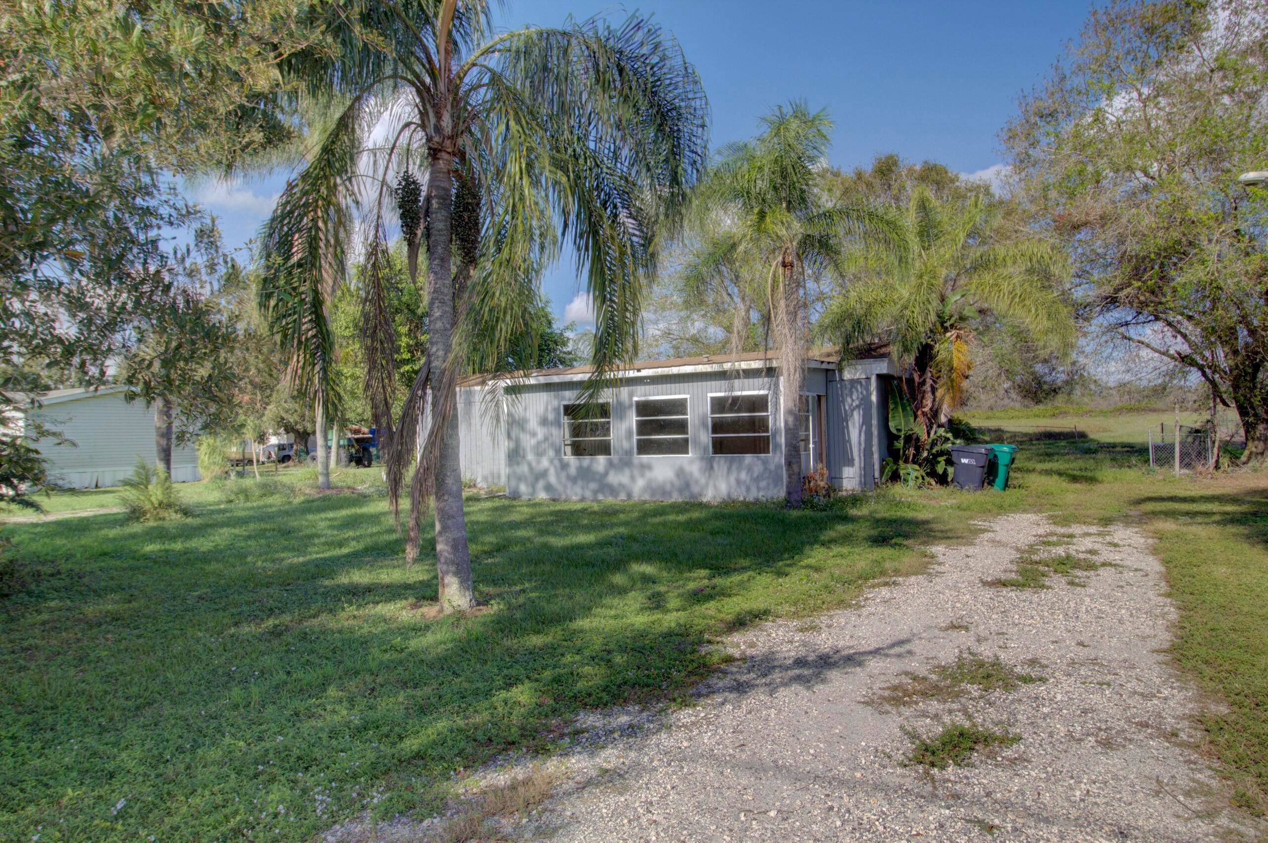 Located in Pioneer Estates this 2 bed, 2 bath fixer upper on a large half acre lot with mature oak trees in Okeechobee.