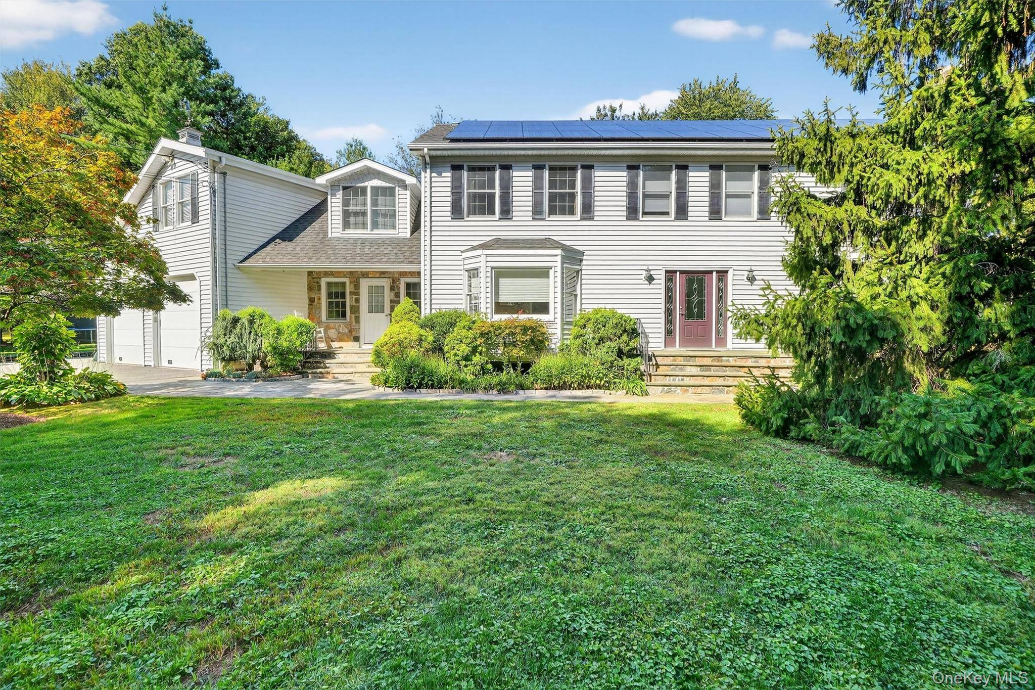 Enter through stately stone pillars and wrought iron gates to this exquisite Center Hall Colonial, perfectly set on nearly one acre of stunning, level, and fully fenced property.