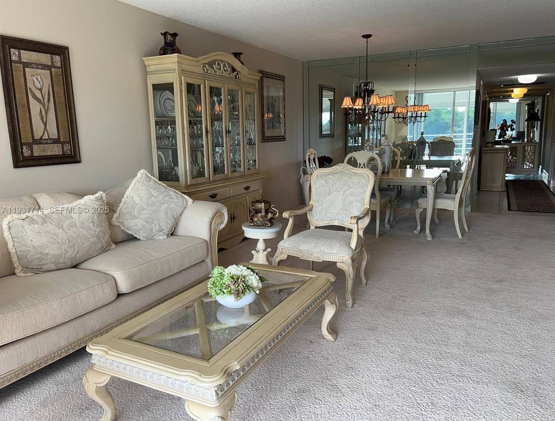 Prime corner 3BD 2BA residence featuring one of the largest wraparound balconies in the building with serene water and golf course views.