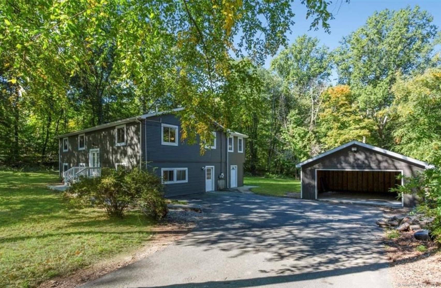 This spacious 4 Bedroom 3 bath Home is situated along a lovely wooded country lane and set back on a level lot with a new 2 car detached garage.