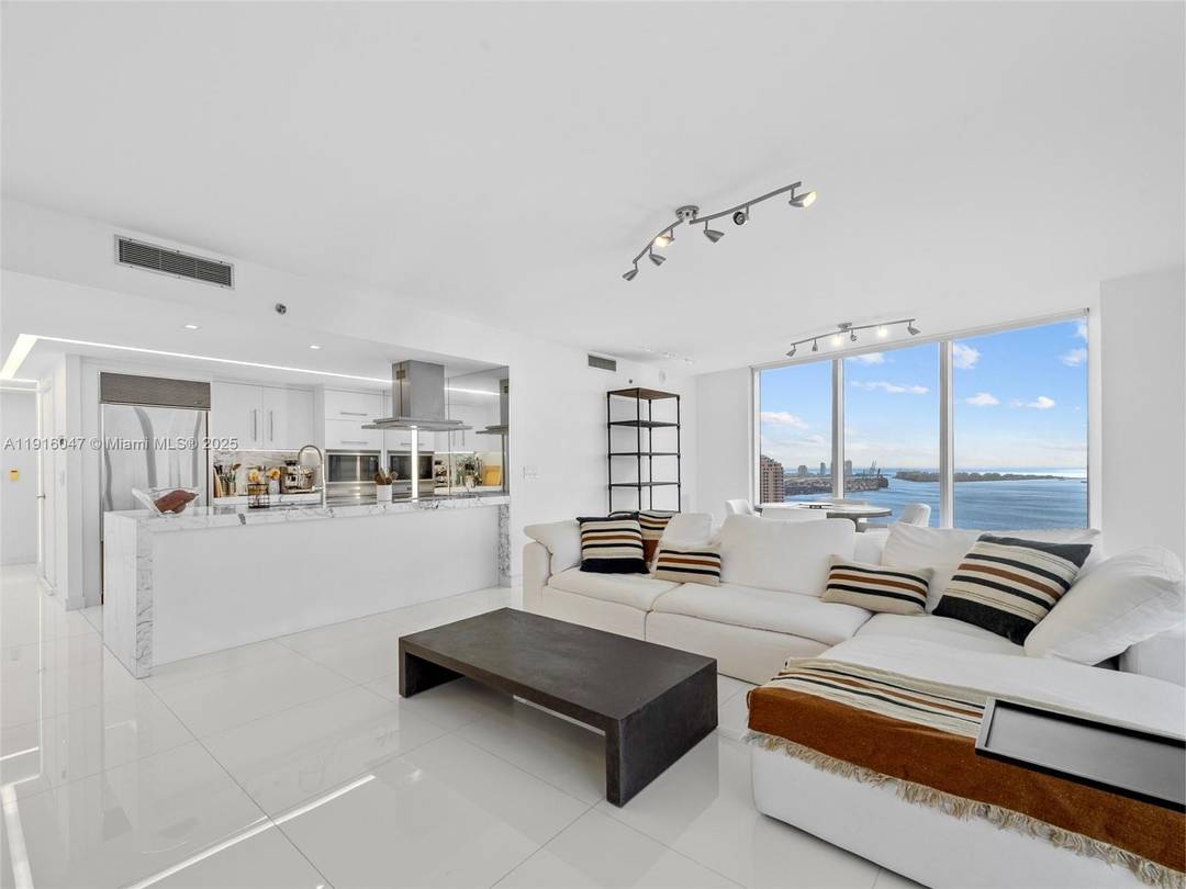 Floor to ceiling glass frames wide water and skyline vistas from this 38th floor condo Icon Brickell.