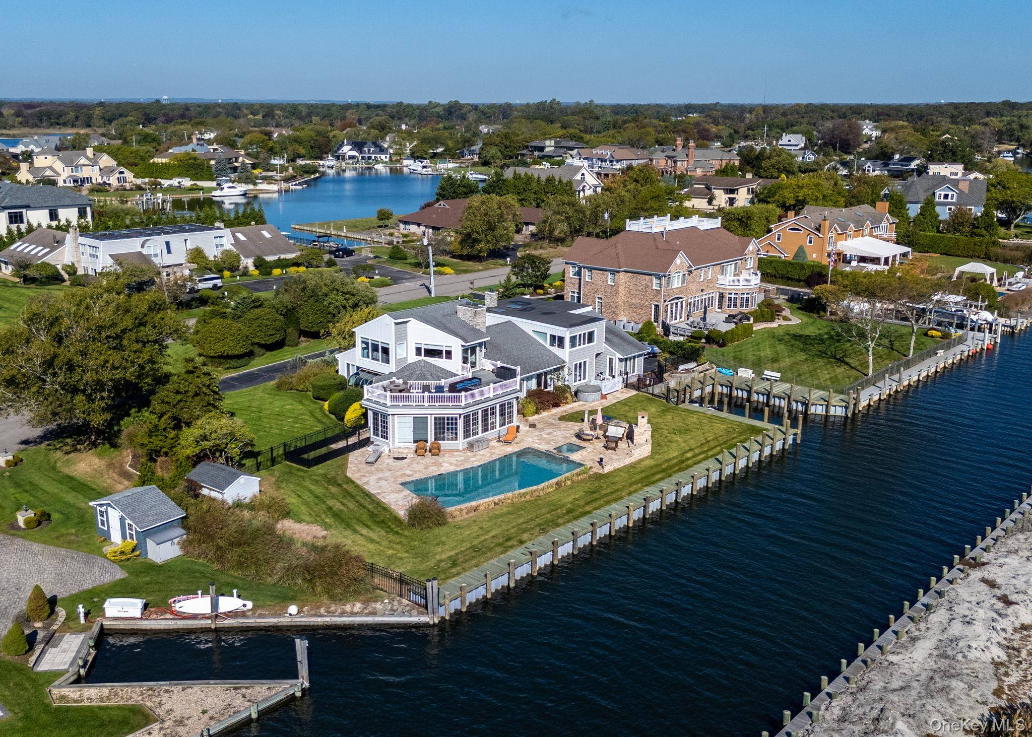 Welcome to your idyllic retreat in this spectacular contemporary waterfront home, perfectly nestled in a tranquil cul de sac within the esteemed gated and guarded community of The Moorings.