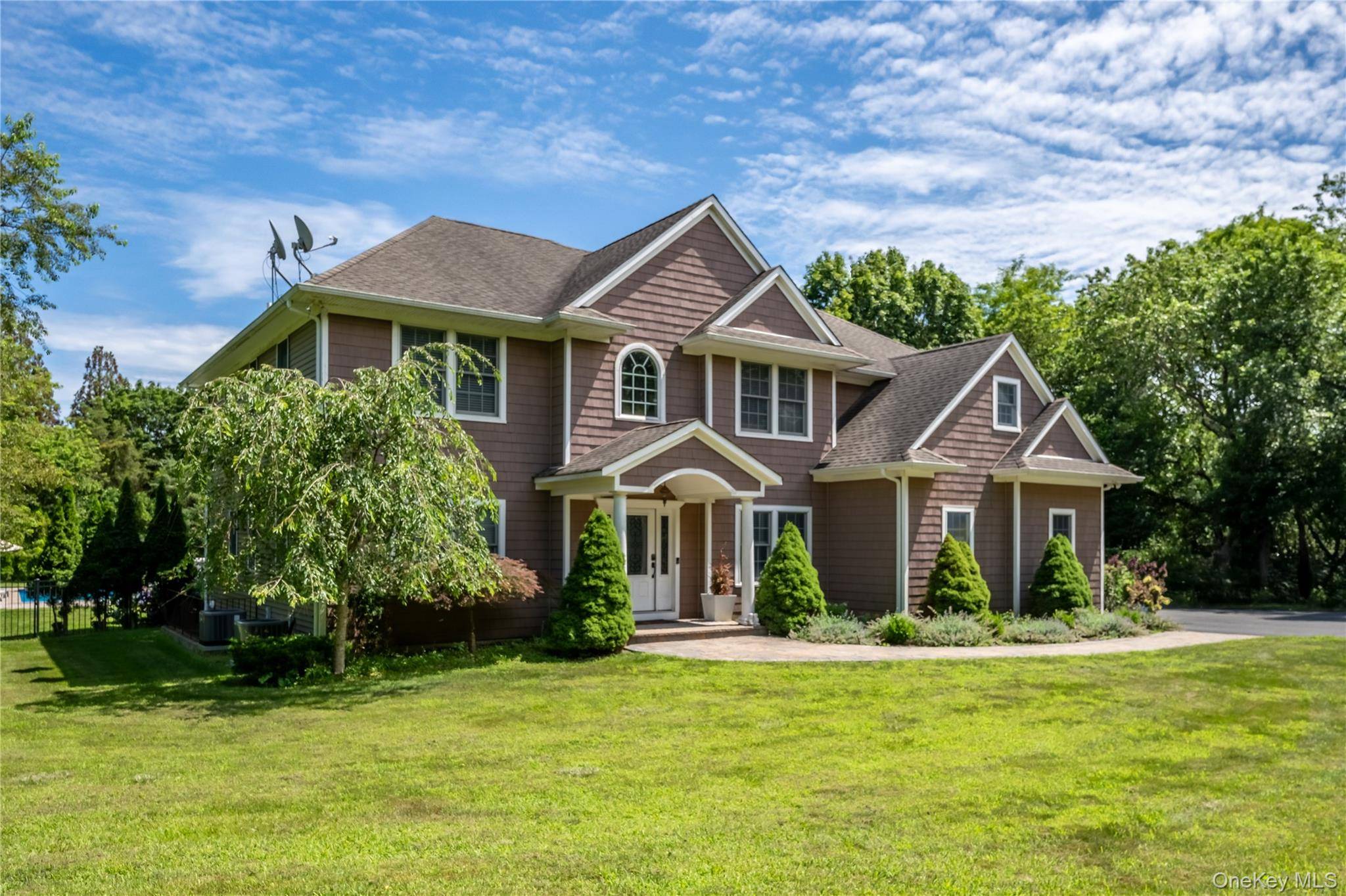 Drive down a picturesque, tree lined driveway and arrive at this stunning post modern home nestled on a spacious, 1.