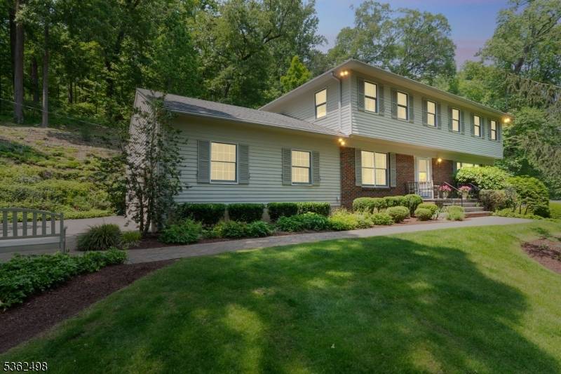 The property features spacious front and side yards, complemented by nearly a quarter acre of tiered rock gardens in the rear your own botanical garden.