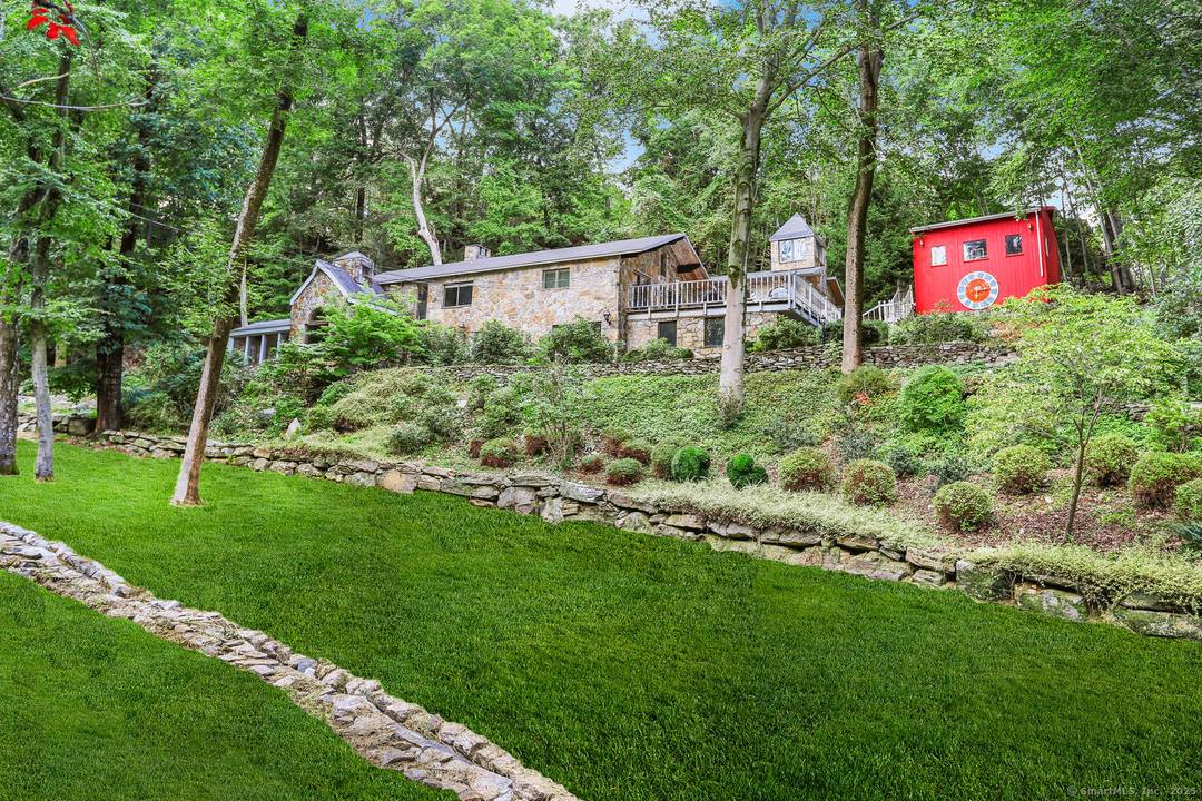 This exceptional stone home, blending contemporary design with natural tranquility, sits on 2 private acres in Weston.