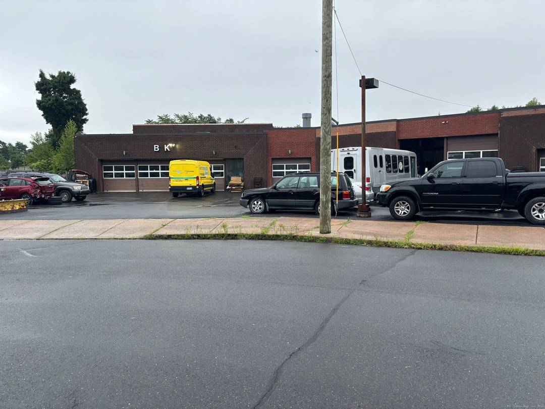 Expansive 11 bay building that currently houses an auto repair auto body shop and licensed car dealership.