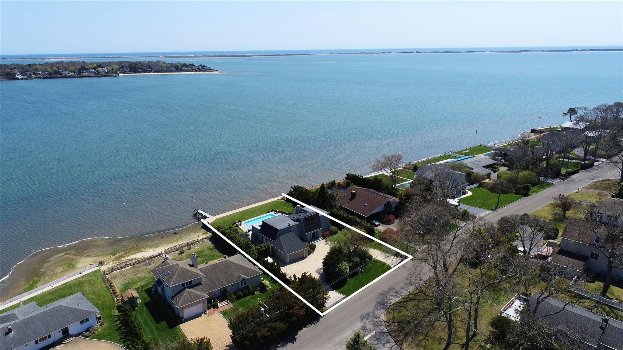 Nestled along Tiana Bay, this exceptional waterfront property in Hampton Bays offers the ultimate summer retreat with breathtaking open water views.