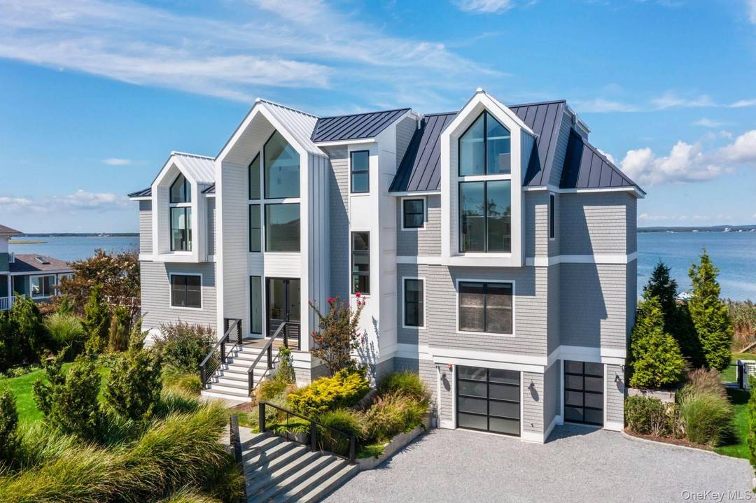 Discover Coastal Elegance at its Finest in Westhampton Dunes Sitting gracefully on 105 feet of open bayfront, this stunning residence epitomizes the pinnacle of modern luxury and design.