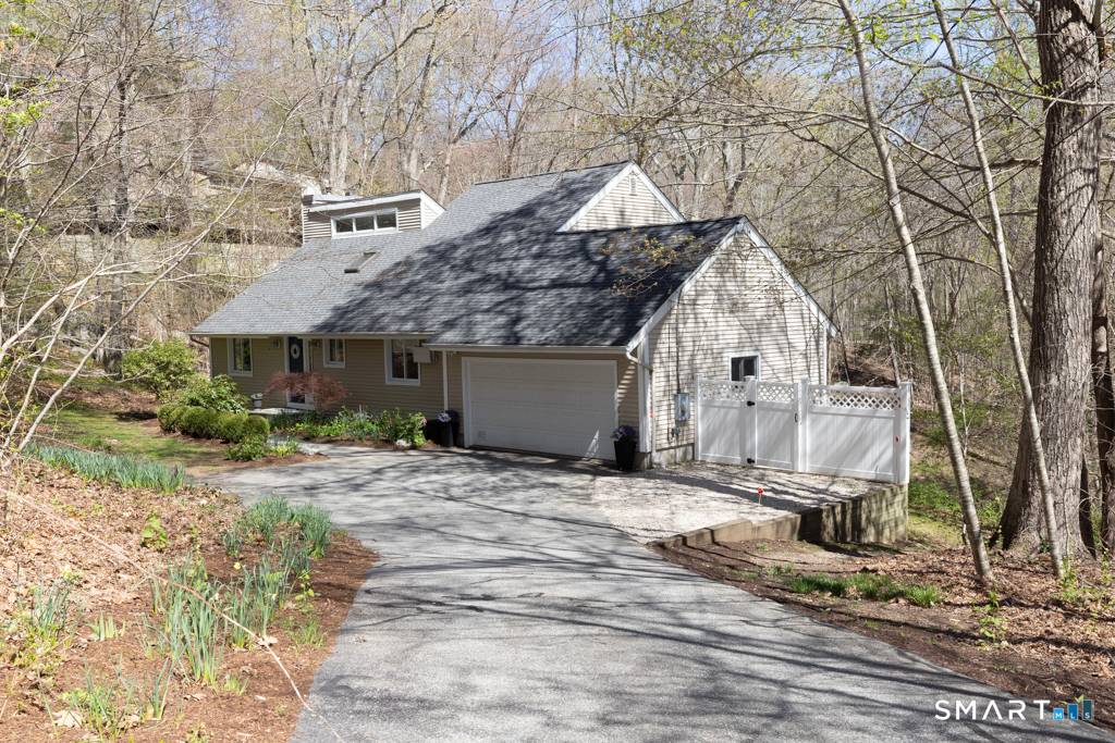 Tucked into a peaceful woodland setting near the scenic Falls River Preserve, this striking contemporary home offers a seamless blend of nature, light, and modern design.