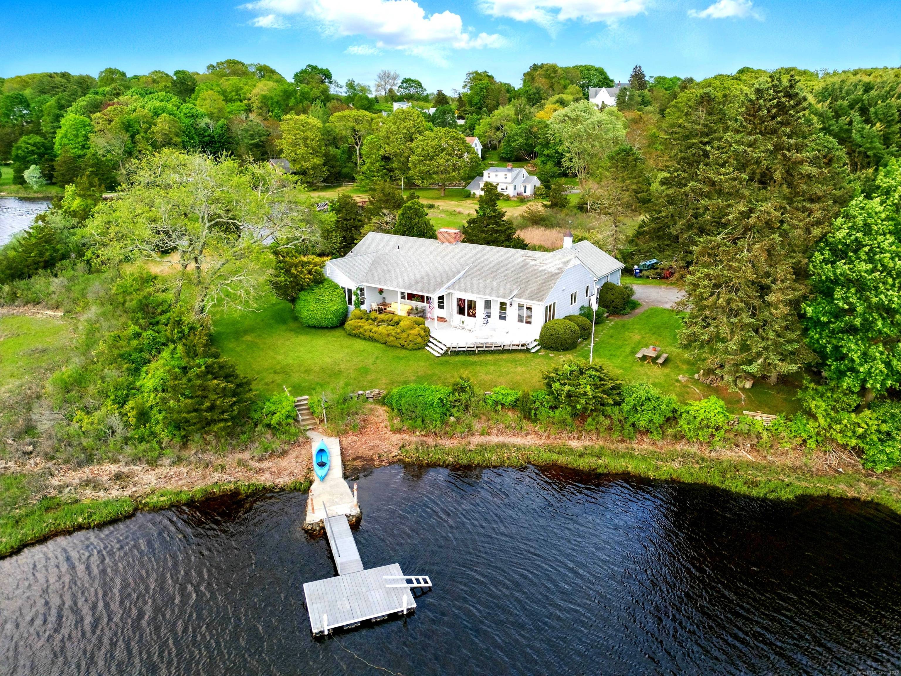 Experience peaceful privacy on over two acres of stunning water frontage on a private road, moments away from the charming downtown Mystic Stonington.