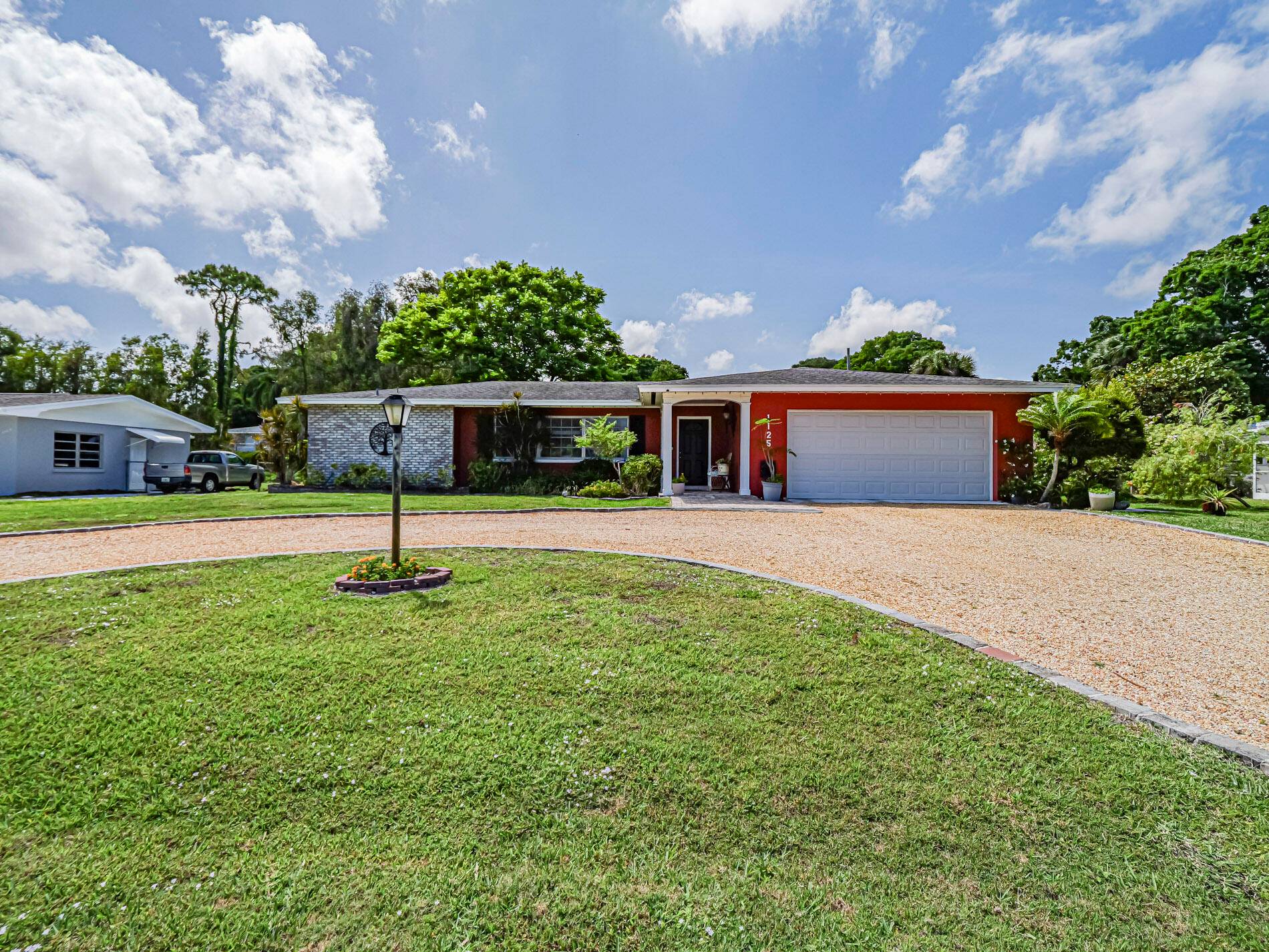 Spacious Ranch with circular, pebbled driveway.