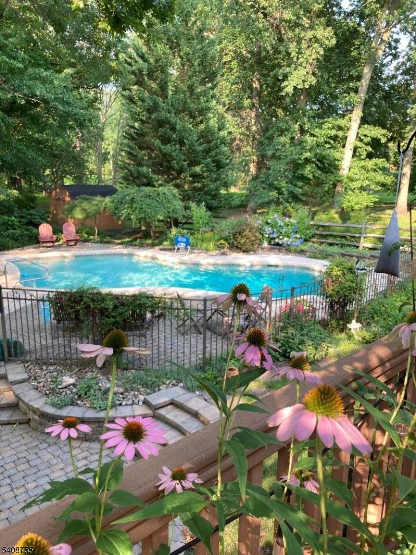 Stately five bedroom brick colonial with stunning inground pool, deck, pond and lush gardens.