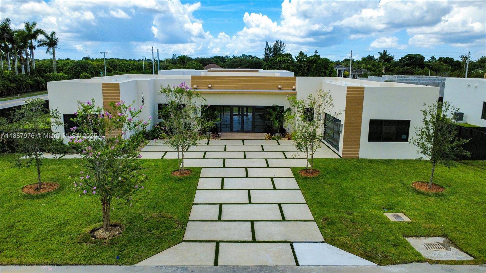 Modern CBS luxury new Construction home with flat TPO roof, hurricane impact door windows, and in law quarters.