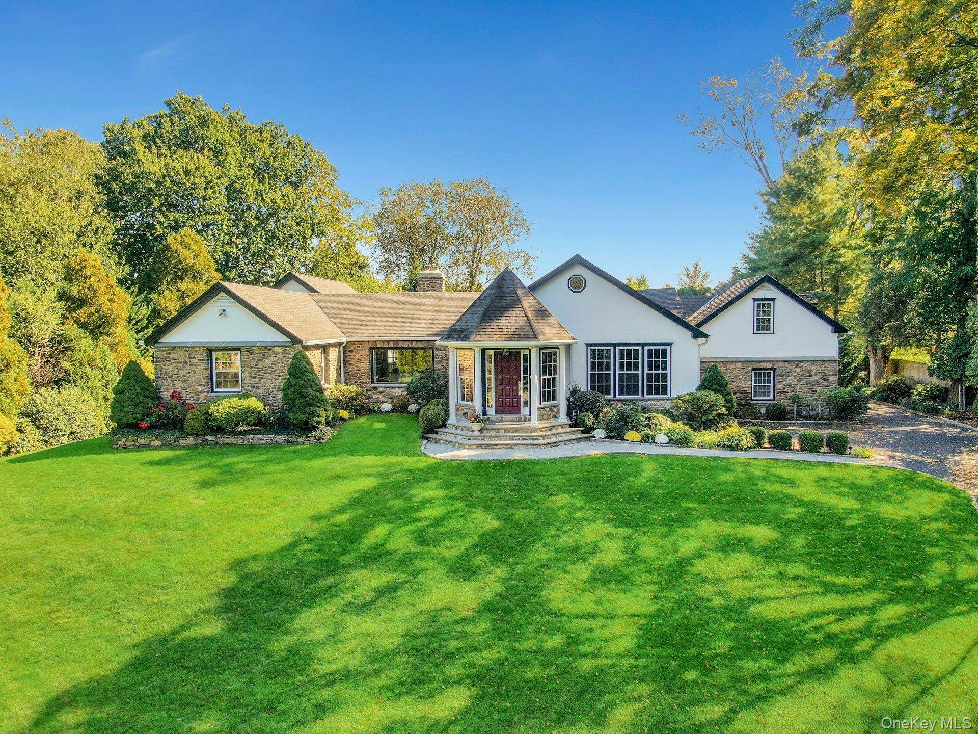 Set atop a hill on over an acre of beautifully landscaped grounds, this distinguished Ranch style residence blends grace, privacy, and effortless one floor living.