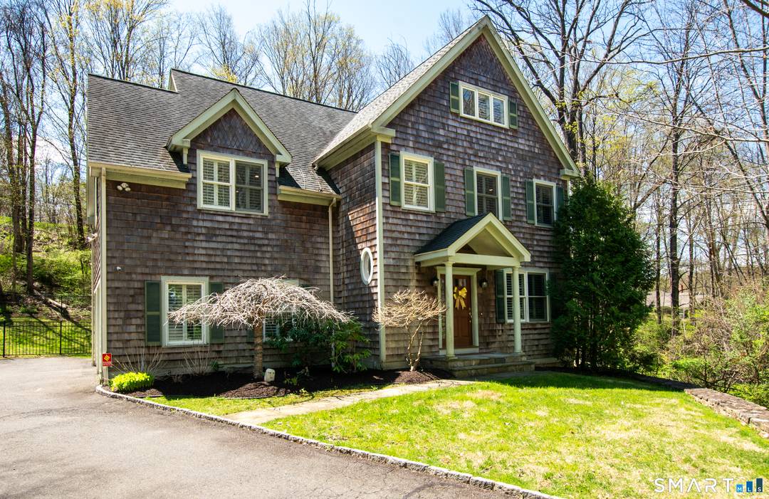 Set on a picturesque property with a private bridge over the Titicus River, this stunning cedar shake Colonial offers exceptional craftsmanship, modern updates, and seamless indoor outdoor living.