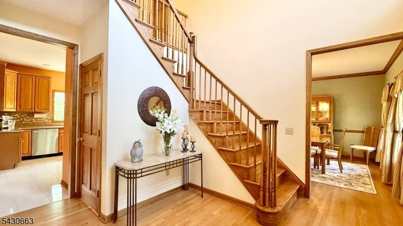 This pristine colonial, with an inviting covered front porch, is situated on a professionally landscaped 1.