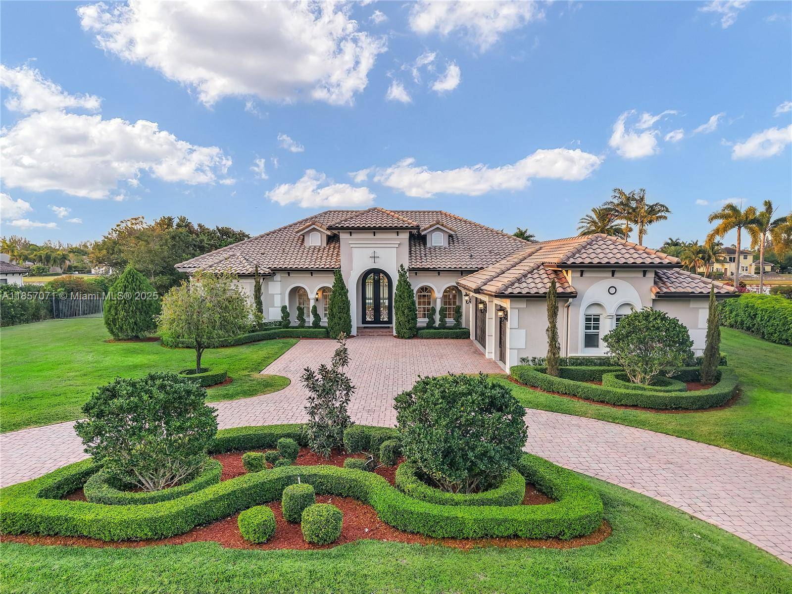 Stunning renovated 5 bedroom, 5 bathroom office lakefront estate on 1 acre in gated Woodbridge Ranches, Davie.
