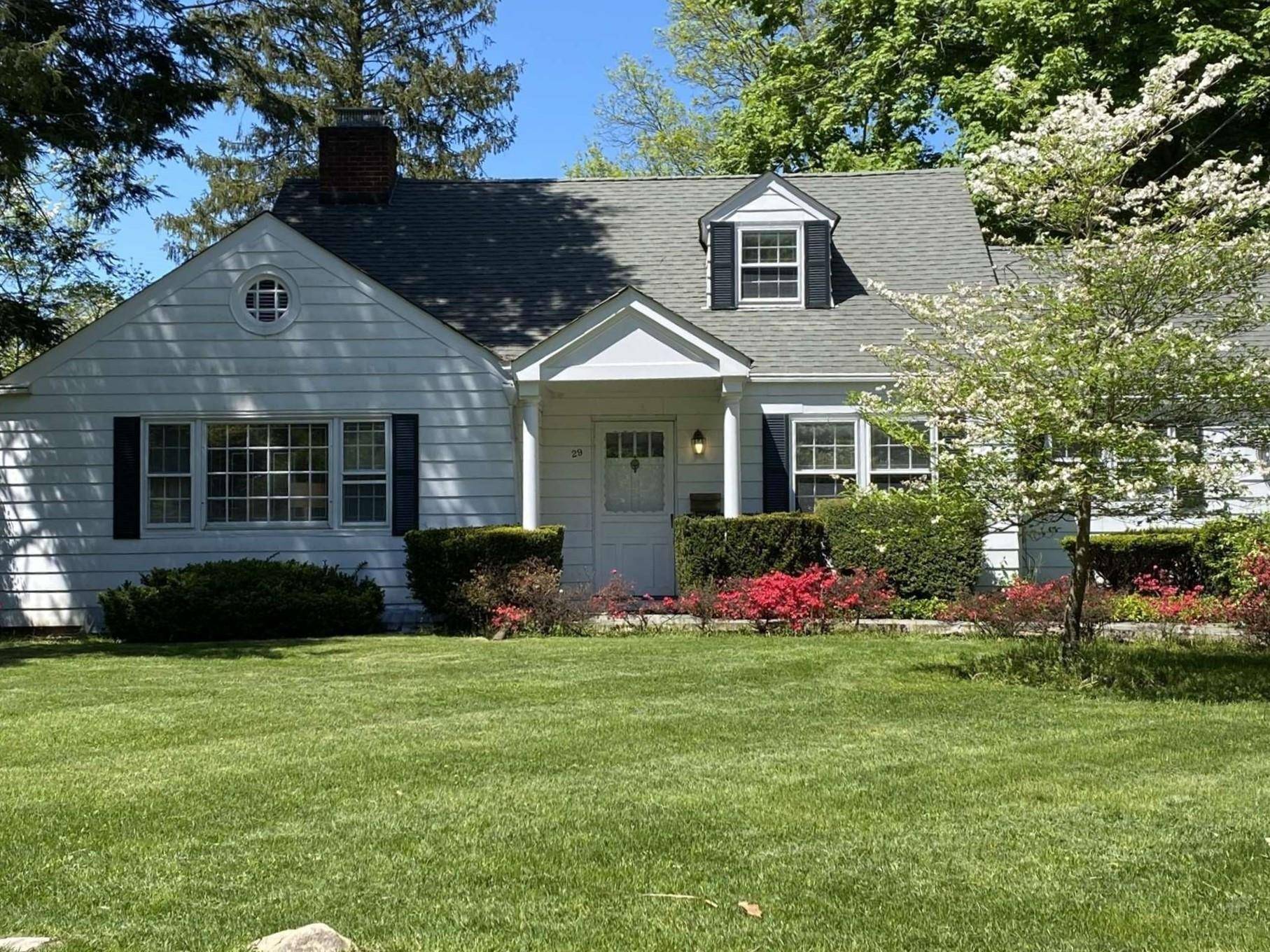 Impeccably charming, cape style residence showcasing generously proportioned rooms, a cozy living room adorned with a rustic brick fireplace, an elegant formal dining room boasting bespoke cabinetry, a modernized kitchen ...