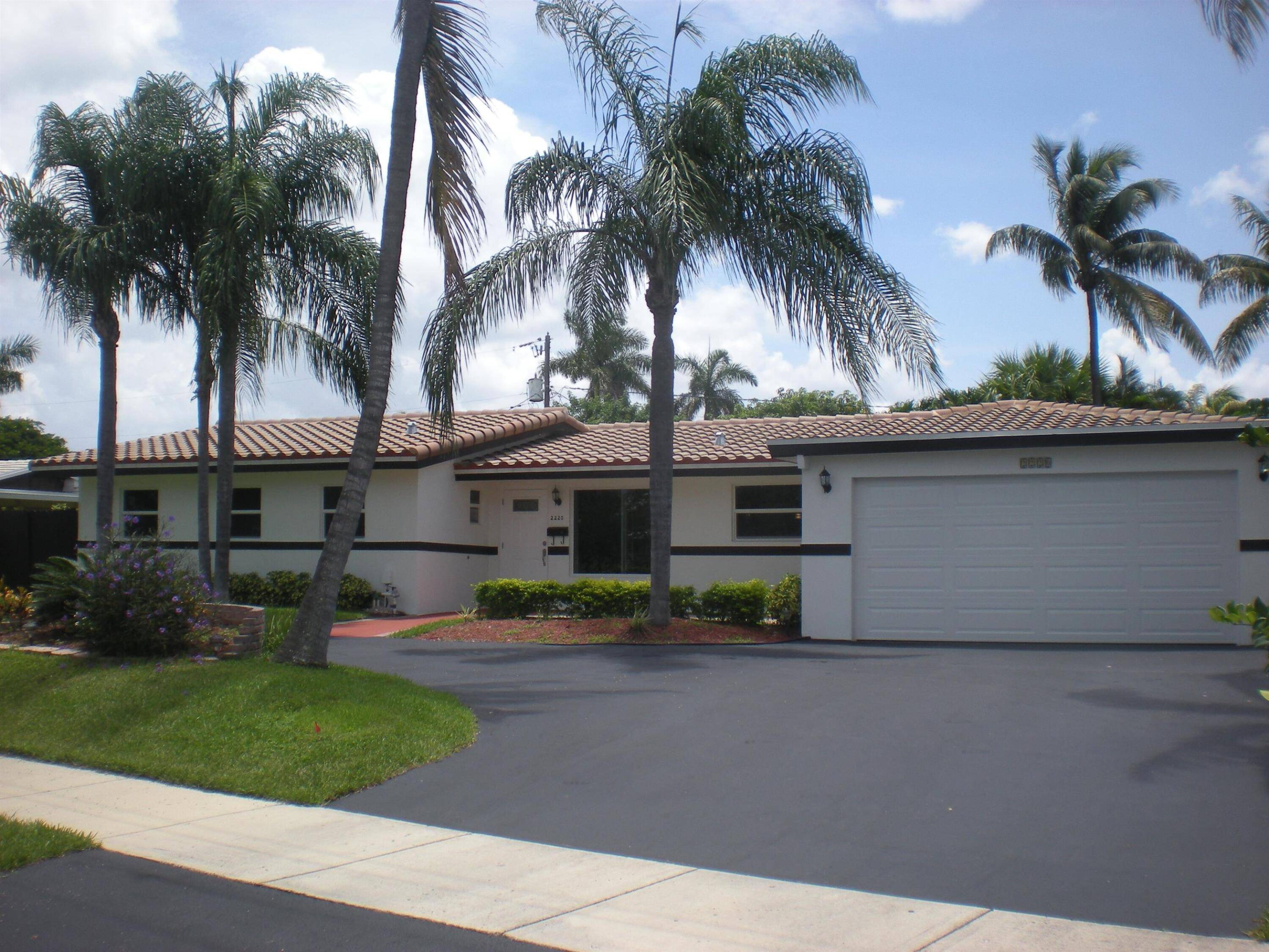 Beautiful split plan 4 BR 2 Masters, 3 BA, 2 car garage with storage or workshop area pool home in prestigious Venetian Isles of Lighthouse Point.