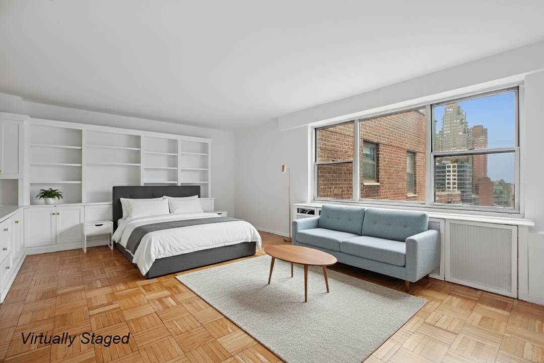 TOP floor, over sized alcove studio in deluxe post war co op in the heart of the Upper East Side.