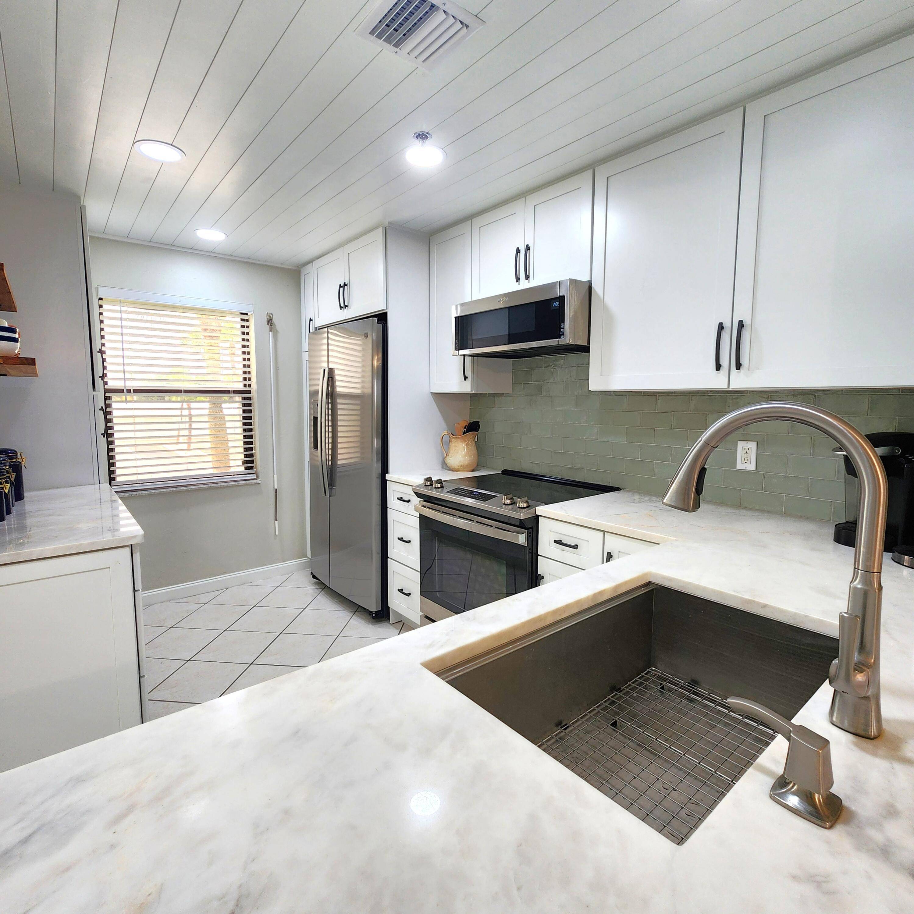 Beautifully renovated CORNER unit with distant ocean view and privacy of State Preserve on north side !