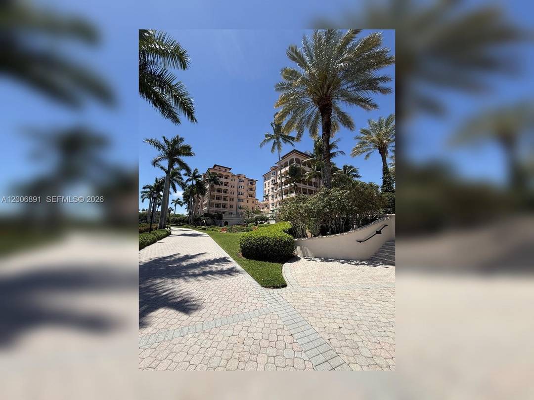 Exceptional corner residence in the Venice at Deering Bay Yacht amp ; Country Club with a 180 wraparound terrace showcasing marina, bay, pool, and lush landscape views.
