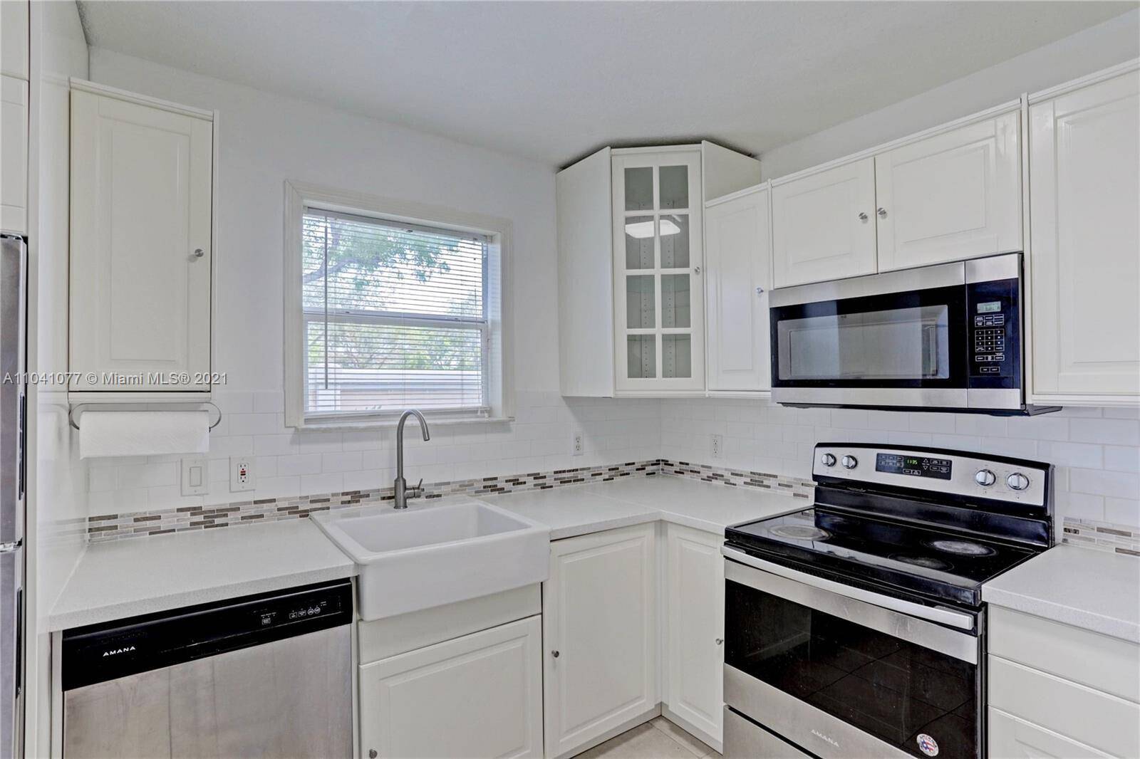 Spacious ground floor corner condo featuring 3 bedrooms and 2 bathrooms, located in a gated community in West Palm Beach.