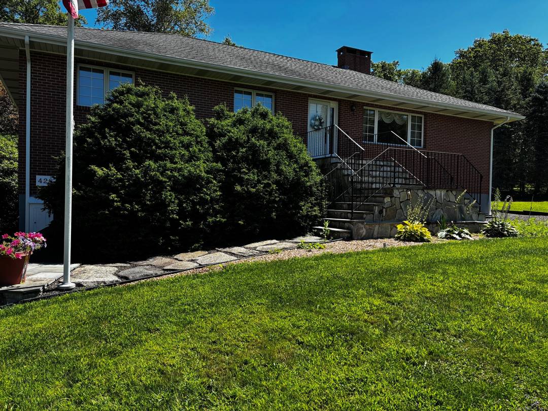 Experience peaceful country living in this charming brick ranch, perfectly positioned on a quiet road amidst beautifully landscaped grounds.