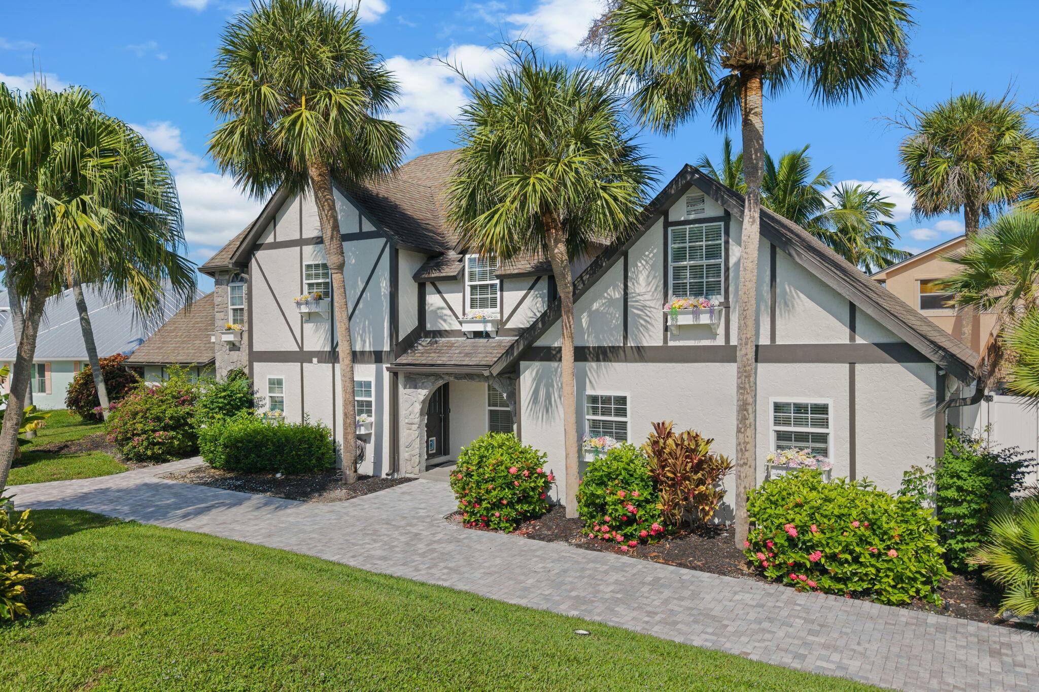 Experience refined coastal living at this Tudor style gem in prestigious Queens Cove.