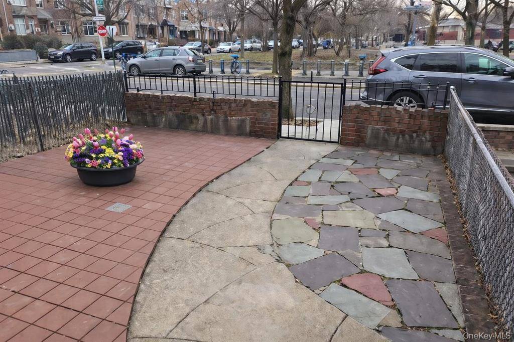 Brick attached single family home with rear garage and driveway parking situated on a quiet residential block in East Elmhurst.